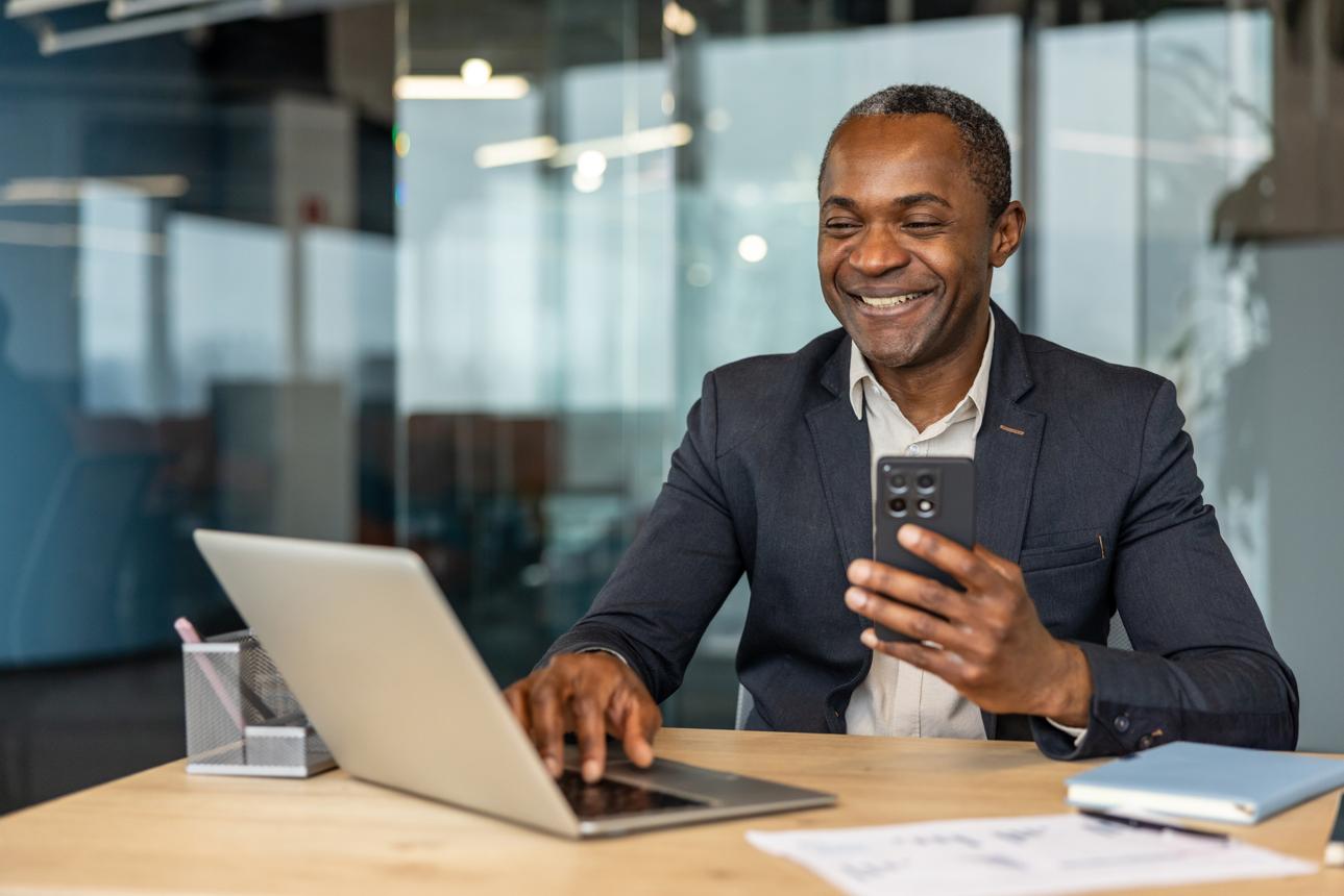 Illustrative professional using a mobile phone and laptop